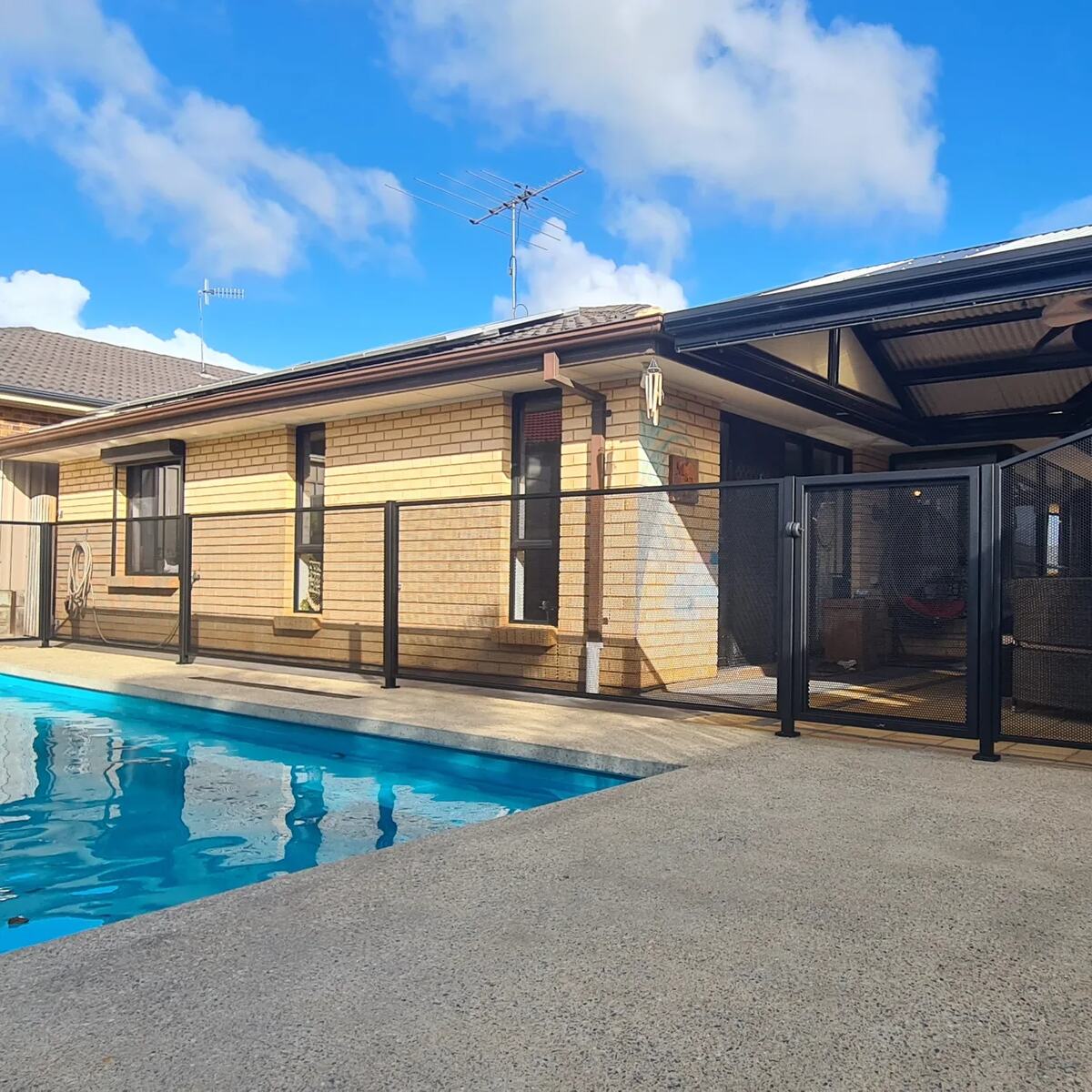 Pure Perf pool fencing in Textured Black beside a bright blue pool, SA